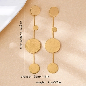 Detailed view showing large geometric gold flower earrings with size and weight specs