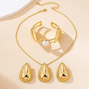 Conjunto de joyas doradas con colgante de gota y brazalete con perla blanca