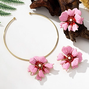 Detail of pink enamel flower jewelry set with gold collar and matching pearl earrings