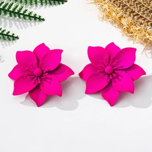 Detailed close-up of fuchsia flower earrings with matte finish on a summer nature backdrop