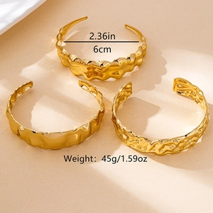 Vue détaillée de trois bracelets dorés texturés avec diamètre de 6cm et poids de 45g