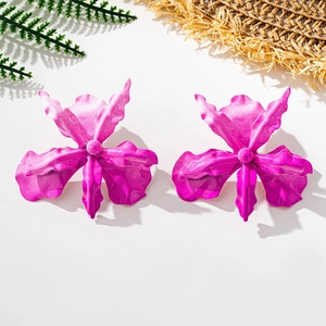 Detailed macro view of rose pink orchid flower earrings with textured metal petals