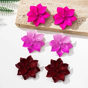 Detailed macro view of colorful multi-layered flower earrings in pink, purple and burgundy