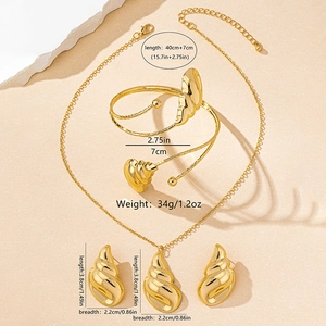 Vista detallada del juego de joyas doradas con motivos de concha, collar, brazalete y pendientes