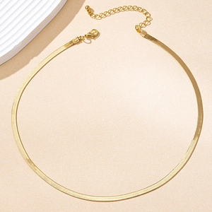 Close-up of golden flat herringbone chain necklace with lobster clasp and extender