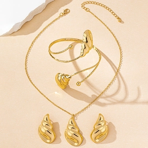 Detalle del conjunto de joyas doradas en forma de concha con collar y brazalete