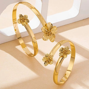Détail macro d'un bracelet de bras spirale doré avec des textures de fleurs à cinq pétales