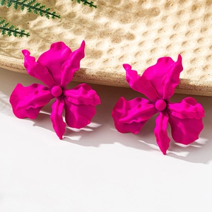 Macro shot of oversized magenta orchid earrings with textured matte finish petals