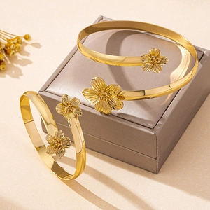 Détail d'un bracelet manchette doré à fleurs texturées avec finition brossée sur écrin