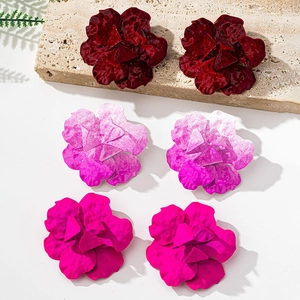 Detailed view of geometric flower stud earrings in burgundy, pink and magenta colors