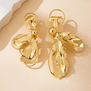 Makro-Detail von goldenen geometrischen Ohrringen mit poliertem Finish und abstraktem Design