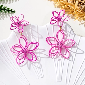 Close-up of peach pink woven flower drop earrings with intricate petal textures