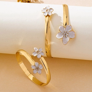 Vue détaillée du bracelet fleuri doré avec pétales en émail violet et blanc élégants