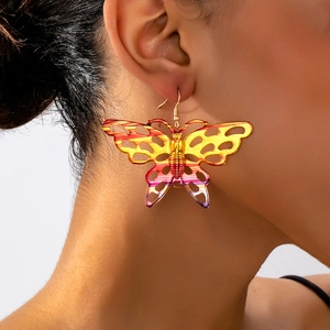 Macro detail of large hollow butterfly earrings with rainbow gradient metallic finish