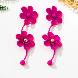 Macro detail of vibrant rose pink double flower drop earrings with a textured lacquer finish