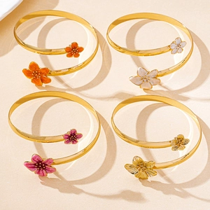 Détail de quatre bracelets dorés à motifs floraux et accents en émail coloré
