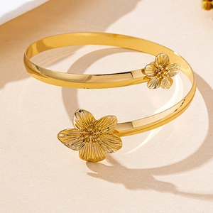 Vue rapprochée d'un bracelet spirale doré aux détails de fleurs sculptées en relief