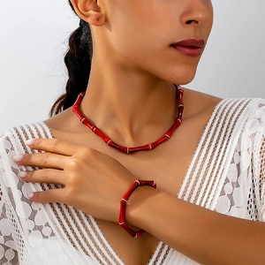 Conjunto de joyas rojas estilo bambú con collar y pulsera con detalles dorados