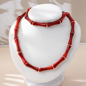 Detalle de conjunto de joyas de cuentas de bambú rojo con separadores dorados