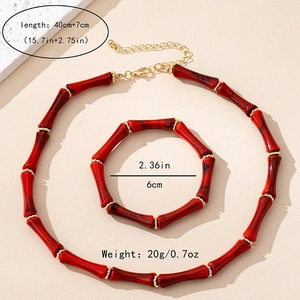 Detalle del conjunto de collar y pulsera rojos con cuentas doradas elegantes