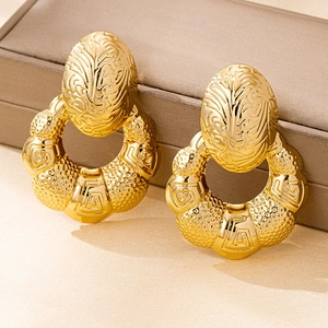 Makroansicht goldener Vintage-Ohrringe mit Blattstruktur und gehämmertem Geo-Design