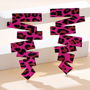 Dettaglio di orecchini maculati rosa acceso con una forma geometrica a zig-zag