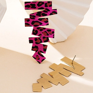 Dettaglio degli orecchini a forma di fulmine con stampa leopardata magenta e retro oro