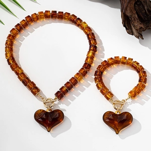 Detailaufnahme des Bernstein-Resin-Schmucksets mit Herzanhänger und goldenem OT-Verschluss