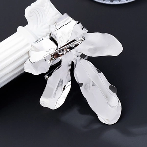 Detailed back view showing the secure metal pin fastening of the silver floral brooch