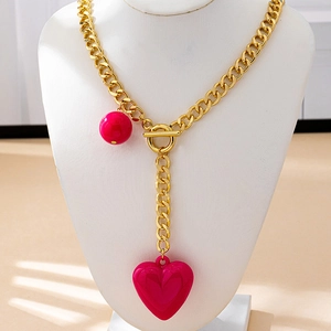 Elegant gold chunky chain necklace featuring a bold pink heart and round ball pendant