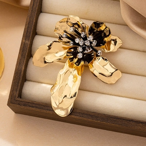 Macro detail of a golden flower brooch with sparkling rhinestones in a wooden gift box