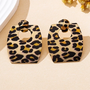 Macro shot of large geometric leopard print earrings with gold and brown matte texture