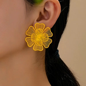 Detalle de los pendientes de flores de malla hueca en acabado amarillo vivo