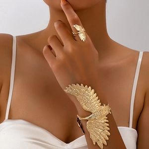 Detail of vintage gold eagle cuff bracelet and matching ring with feather texture