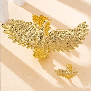 Detailed view of two gold phoenix jewelry pieces with intricate feather carving details
