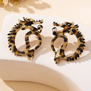 Detailed close-up of golden dragon hoop earrings with leopard print and pearl accents