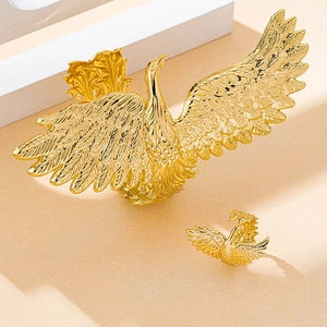 Detailed close-up of golden swan shape jewelry set with intricate feather texture