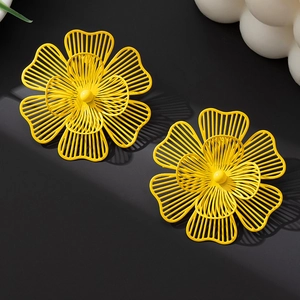 Detalle de pendientes de flores amarillas huecas con diseño de pétalos de metal en capas