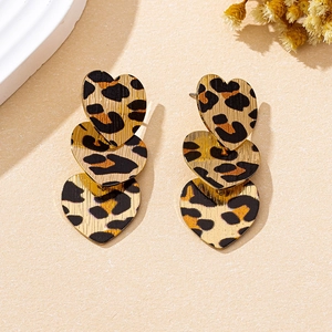 Detail view of triple leopard print heart earrings with brushed gold metallic finish