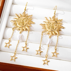 Macro detail of gold sun face earrings with white crescent moon and hollow stars