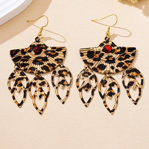 Detail of leopard print fan-shaped earrings with red gemstone and leaf pendants