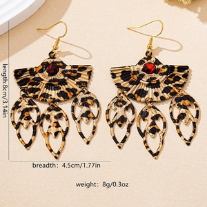Detailed view of leopard print fan earrings with red gems and leaf-shaped pendants