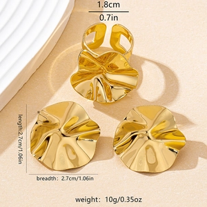 Detailed view of irregular gold-plated geometric earrings and ring set with wrinkled texture