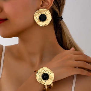 Vintage gold hammered metal jewelry set with black gems on fashion model