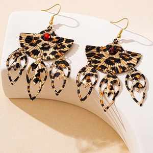 Macro detail of fan-shaped leopard print earrings with red gemstone and leaf charms