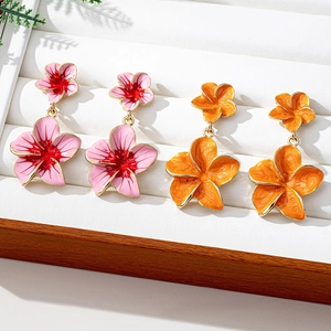 Detailed close-up of colorful camellia flower drop earrings with golden enamel edges