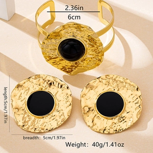 Detailed view of bohemian gold hammered metal jewelry set with black circular accents