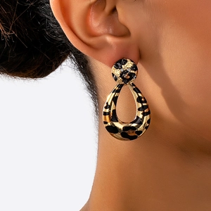 Close-up of vintage leopard print teardrop earrings with gold textured studs on model