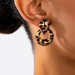 Macro shot of stylish gold earrings with leopard print dangling in a round hollow design