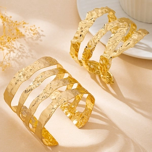 Dettaglio di un bracciale a fascia dorata irregolare a strati con trama martellata